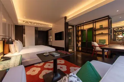 a bedroom with a bed and a living room at Hotel Indigo Kuala Lumpur on the Park by IHG in Kuala Lumpur