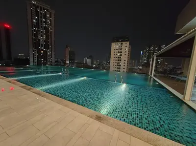 a swimming pool on top of a building at night at Chambers Residence by FANTASTIC in Kuala Lumpur