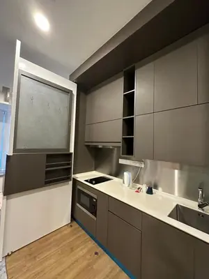 a kitchen with gray cabinets and a sink and a window at Ceylonz Suites KLCC, Bkt Bintang in Kuala Lumpur