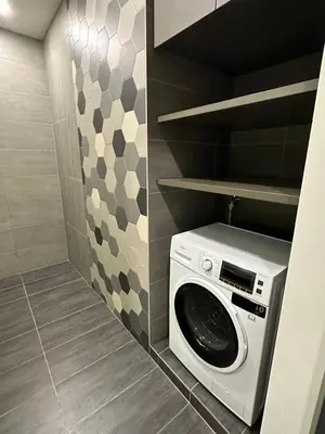 a washer and dryer in a small bathroom at Ceylonz Suites KLCC, Bkt Bintang in Kuala Lumpur