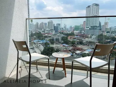 a balcony with two chairs and a table and a city at Aletheia Studio at KLCC in Kuala Lumpur