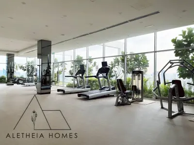 a gym with cardio equipment in a building with windows at Aletheia Studio at KLCC in Kuala Lumpur