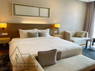 a hotel room with a large bed and a chair at Aletheia Studio at KLCC in Kuala Lumpur