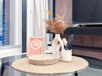 a table with a plate and a vase on it at Tropicana The Residence Hermes Suite with KLCC View in Kuala Lumpur