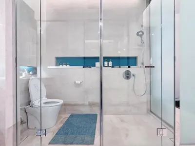 a bathroom with a toilet and a glass shower at Tropicana The Residence Hermes Suite with KLCC View in Kuala Lumpur