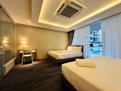 a hotel room with two beds and a desk and a window at The Bed Bukit Bintang in Kuala Lumpur