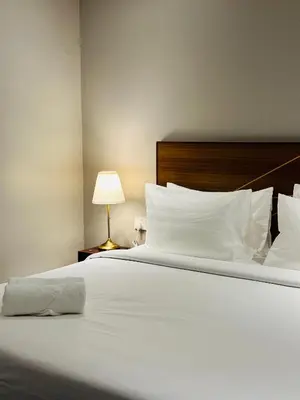 a bedroom with a large white bed with a lamp at The Bed Bukit Bintang in Kuala Lumpur