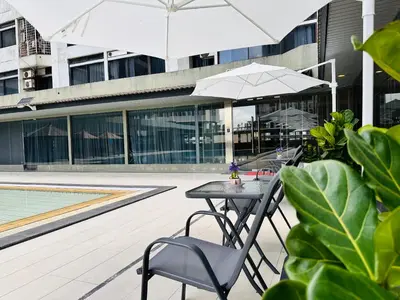 a table and chairs with an umbrella in front of a building at The Bed Bukit Bintang in Kuala Lumpur