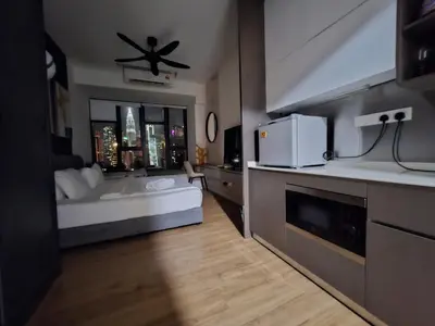 a room with a bed and a kitchen with a microwave at Ceylonz Suites By ANA MALAYSIA in Kuala Lumpur
