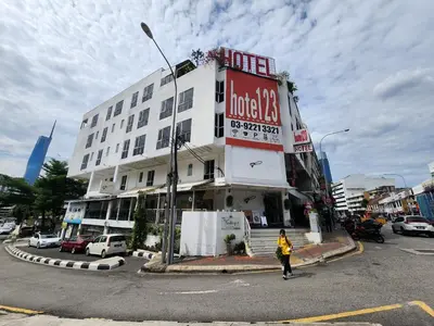 a woman crossing a street in front of a building at Boutique Hote123 in Kuala Lumpur