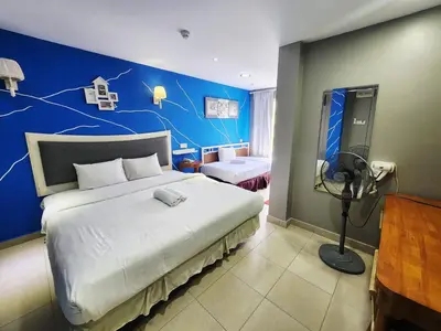 a bedroom with a large bed with a blue wall at Boutique Hote123 in Kuala Lumpur