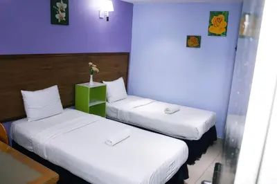 two beds in a room with purple walls at Boutique Hote123 in Kuala Lumpur