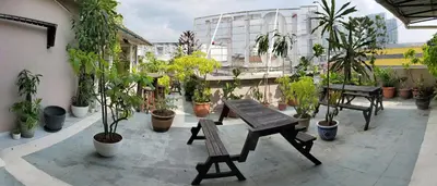 a patio with a table and chairs and potted plants at Boutique Hote123 in Kuala Lumpur