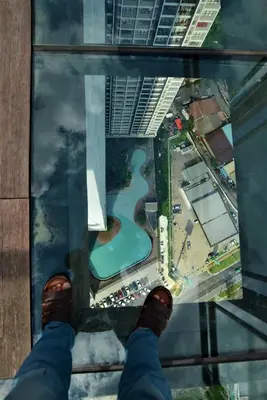 a person standing on the glass floor of a building at Suasana Homestay Kewingston Platz in Kuala Lumpur