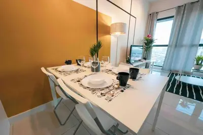 a dining room table with plates and glasses on it at Continew Residence Cozy Suite by GUESTONIC in Kuala Lumpur