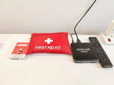 a first aid kit and a remote control on a table at KLCC Night View Spacious Muji MITEC 3min 121CAE in Kuala Lumpur