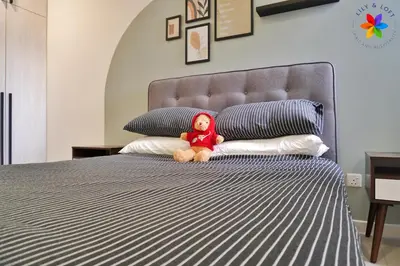a teddy bear sitting on a bed with pillows at The Pano @ Jalan Ipoh by Lily and Loft in Kuala Lumpur