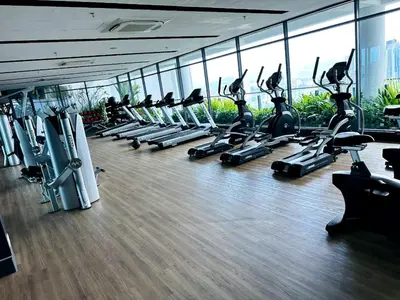 a gym with a row of treadmills and ellipticals at The Colony Stay Well studio with KL View in Kuala Lumpur