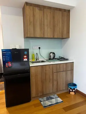 a kitchen with a black refrigerator and a sink at The Colony Stay Well studio with KL View in Kuala Lumpur