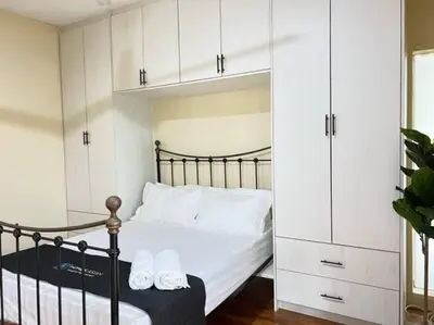 a bedroom with a bed with white cabinets at Bungalow with Pool Karaoke PJ 12 in Petaling Jaya