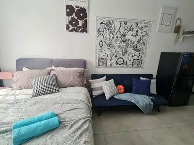 a bedroom with a bed and a couch with pillows at Contemporary 2R2B Studio 10 minutes from KLCC in Kuala Lumpur
