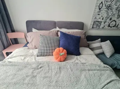 a bed with pillows and a orange ball on it at Contemporary 2R2B Studio 10 minutes from KLCC in Kuala Lumpur