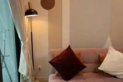 a couch with pillows sitting next to a lamp at OOAK SUITES AT MONT KIARA KUALA LUMPUR in Kuala Lumpur