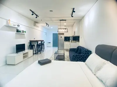a living room with a bed and a kitchen at Mercu Summer Suites KLCC by GRIHOZ Homestay in Kuala Lumpur
