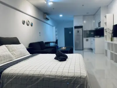 a black hat sitting on top of a bed in a room at Mercu Summer Suites KLCC by GRIHOZ Homestay in Kuala Lumpur