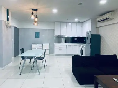 a kitchen and living room with a table and chairs at Mercu Summer Suites KLCC by GRIHOZ Homestay in Kuala Lumpur