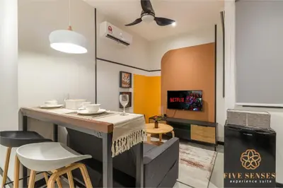 a living room with a table with chairs and a tv at Neu Suites Residence Kuala Lumpur, Roam in Kuala Lumpur