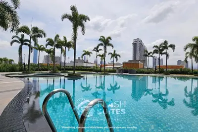 a swimming pool with palm trees in a city at Trion Premium Suites @ KL in Kuala Lumpur