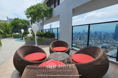 a patio with wicker chairs and tables on a building at Trion Premium Suites @ KL in Kuala Lumpur