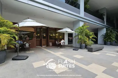 a restaurant with tables and umbrellas in front of a building at Trion Premium Suites @ KL in Kuala Lumpur