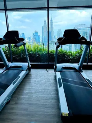 two exercise bikes in a room with a view of a city at Relax Bedroom Studio, The Luxe in Kuala Lumpur