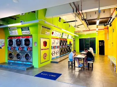 a group of people sitting at a table in a laundry room at Relax Bedroom Studio, The Luxe in Kuala Lumpur