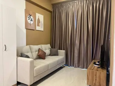 a living room with a white couch in front of a window at Relax Bedroom Studio, The Luxe in Kuala Lumpur