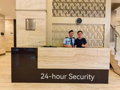 two people standing at a counter in a lobby at 5 Bukit Bintang 5 minutes to Alor Street Bukit Ceylon KLCC Pavilion Apt 3R2B 10 pax in Kuala Lumpur