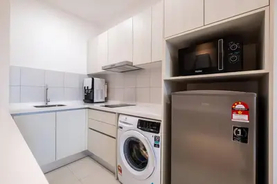 a kitchen with a washing machine and a microwave at Chambers near PWTC SunwayPutra KLCC InfinityPool in Kuala Lumpur