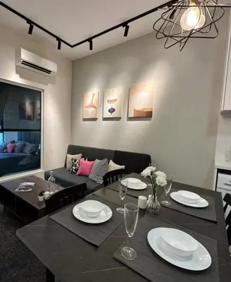 a dining room with a table and a couch at Arte Mont Kiara Pool View in Kuala Lumpur