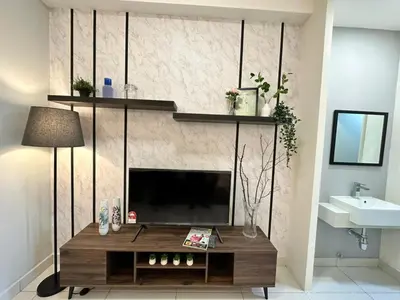 a living room with a television on a wall at Arte Mont Kiara Pool View in Kuala Lumpur