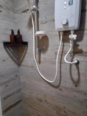 a shower with a white hose attached to a wall at Arte Mont Kiara Pool View in Kuala Lumpur