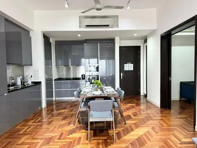 a dining room with a table and chairs and a kitchen at TTs HOME3 Mews 4-8Pax Pavilion KLCC Kuala Lumpur in Kuala Lumpur
