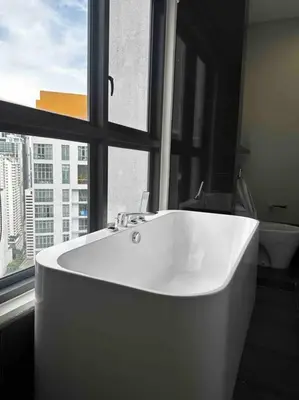 a white bath tub in a bathroom with a window at TTs HOME3 Mews 4-8Pax Pavilion KLCC Kuala Lumpur in Kuala Lumpur
