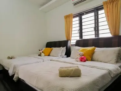 two beds with a teddy bear sitting on top of them at The 29 Bungalow Setapak KL by Manhattan Group in Kuala Lumpur