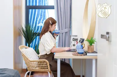 a woman sitting at a table with a laptop at Zen-Inspired Duplex Luxury 6Pax, Arte Mont Kiara by Verano in Kuala Lumpur