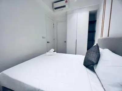 a bedroom with a large white bed with a white bedspread at Axon Serviced Suites Kuala Lumpur in Kuala Lumpur