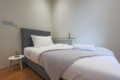 a bedroom with a bed and a side table at Sky Suite KLCC, Calm Sojourn in Kuala Lumpur