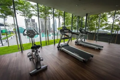 a gym with three exercise bikes in a room with windows at Maxhome Cozy at Dorsett Bukit Bintang in Kuala Lumpur