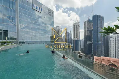 people swimming in a infinity pool on the roof of a building at Maxhome Cozy at Dorsett Bukit Bintang in Kuala Lumpur